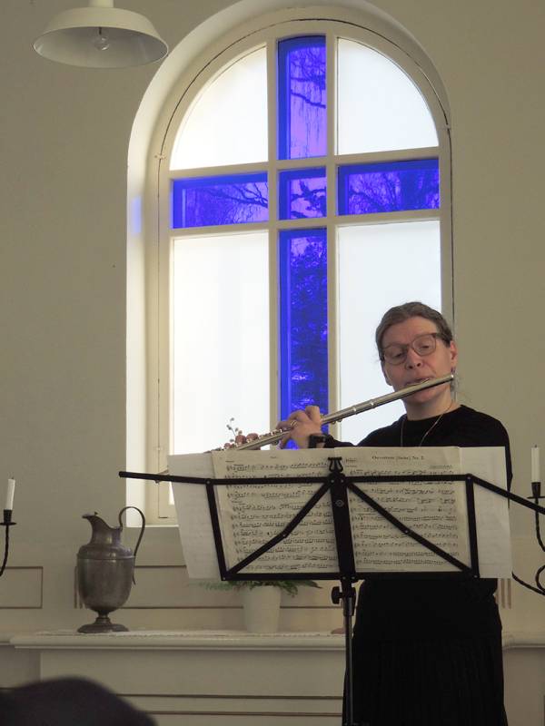 Huilisti Ritva-Liisa Salonen soitti taustanaan alttari-ikkunan siniristi. Kuva: